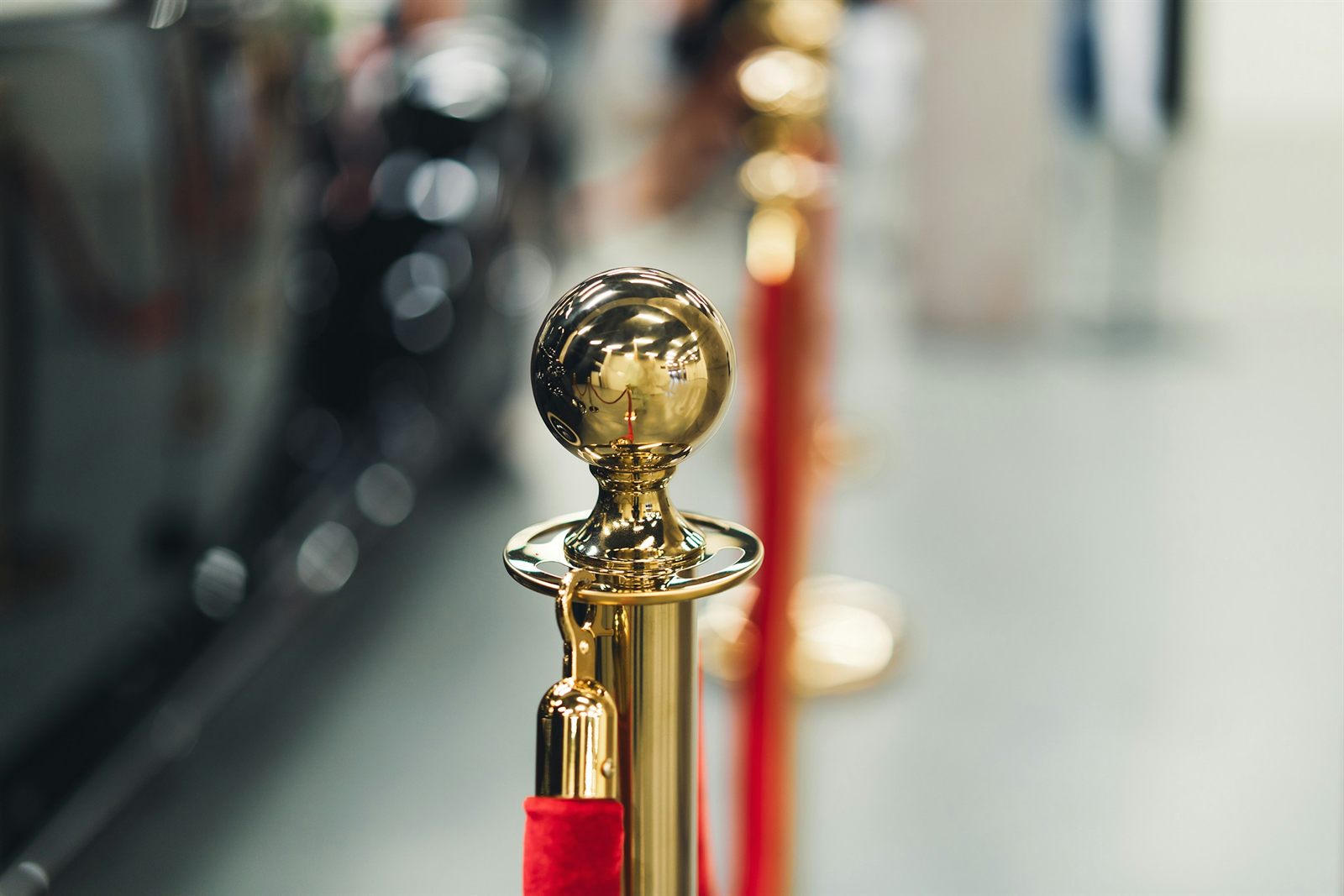 A gold stanchion and red velvet rope at a private entrance